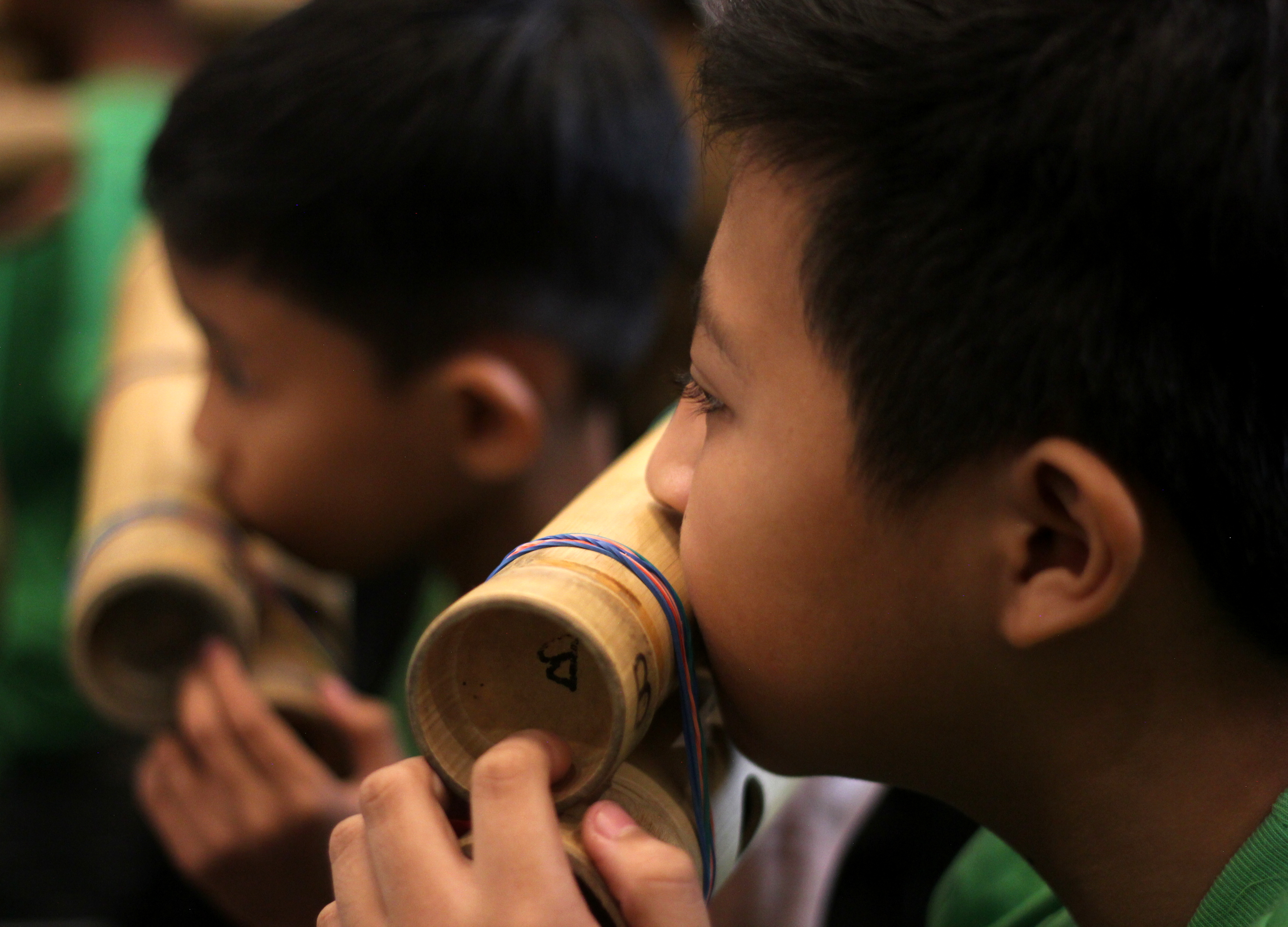 Members of the band play the tipangklung (above) and bumbong (below).