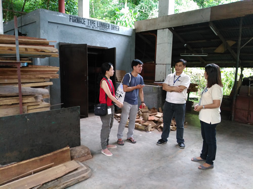 Engr. Caesar A. Cuaresma and For. Zenaida R. Reyes (in white uniforms) explain how DOST-FPRDI’s lumber dryer operates.