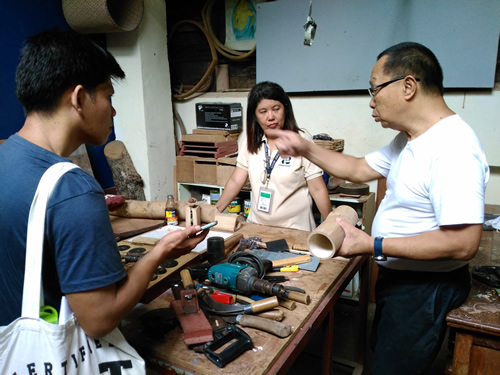 Mr. Eduardo A. Atienza (in white shirt) presents some of the tools he uses for bamboo handicraft production.