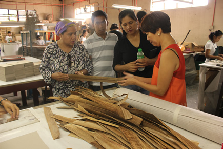 Ms. Tess Donato, the manager of Magic Clean (in orange) talks about the demand for dried water hyacinth.